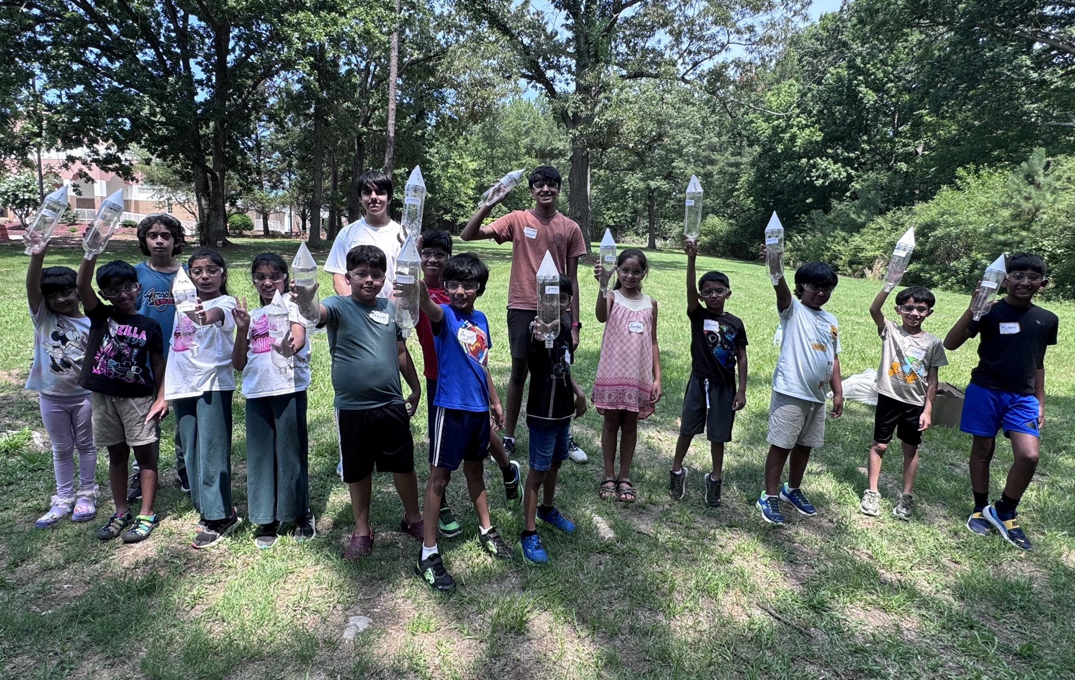 Camp students and instructors standing outdoors with their completed bottle rockets