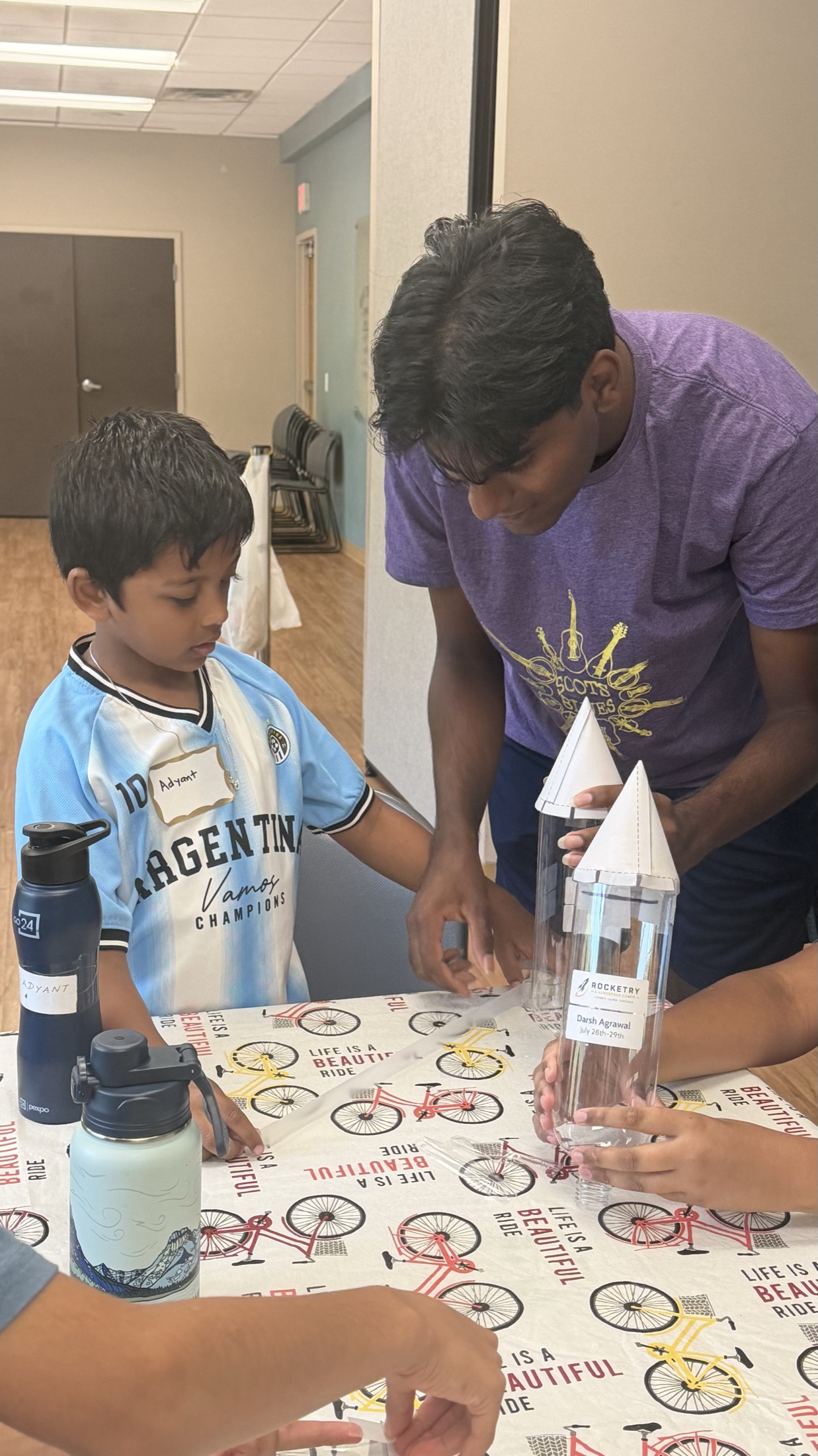An instructor helping a student construct a bottle rocket